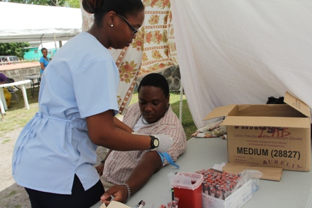 A member of the public getting tested on Voluntary Counseling and Testing (VCT) Day in 2012 by a Lab Technician from the Alexandra Hospital on Nevis